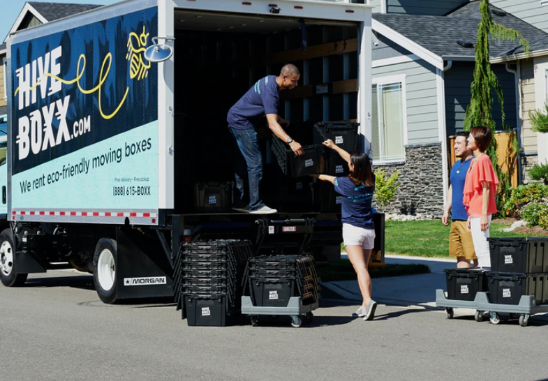 Moving truck moving boxes into truck.