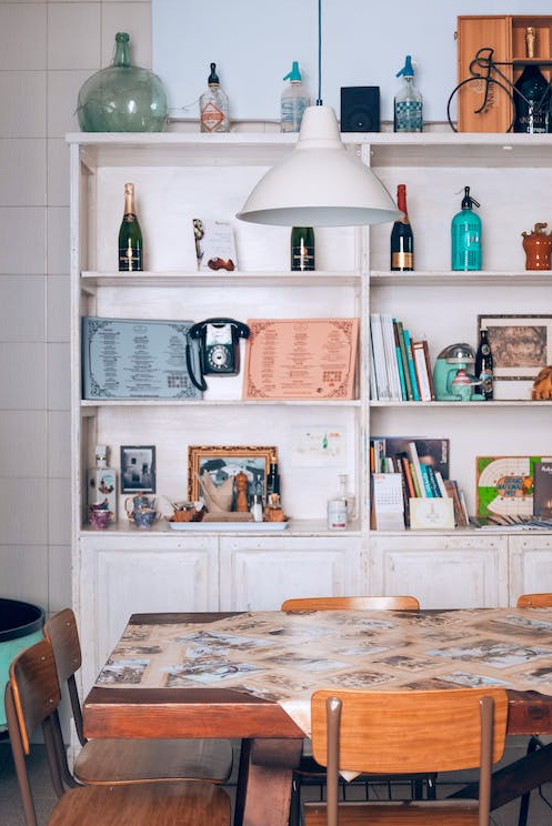 Antiques and treasures stored on shelving in a kitchen.