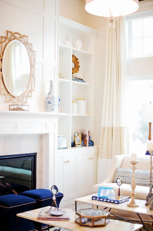 White walls with gold gilded mirror and blue sofa living room decorating.
