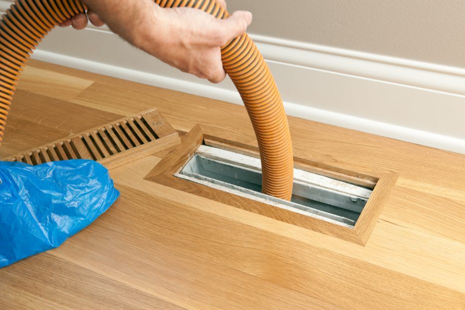 Cleaning the vents and air ducts in a home with hose.